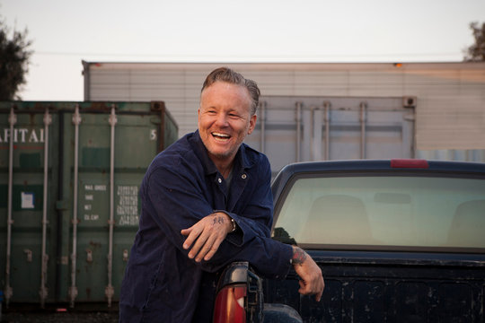 Man leaning against truck smiling