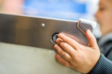 Cropped view of boy's hand pressing button on pinball machine