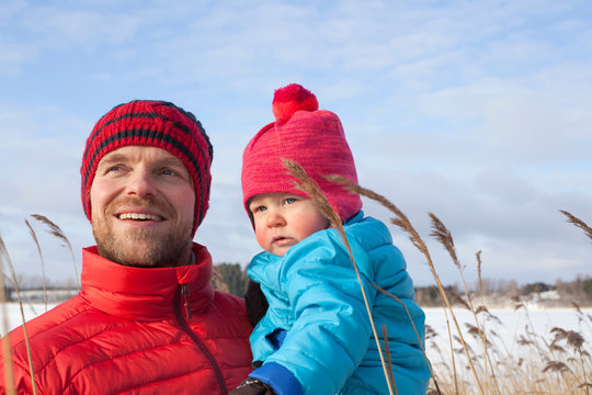 Father holding young son in snow covered landscape