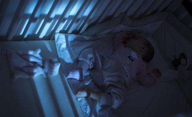Adorable baby sleeping in blue at night