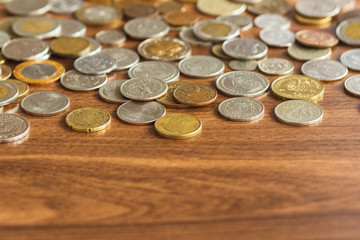 Different gold and silver collector's coins on the wooden table