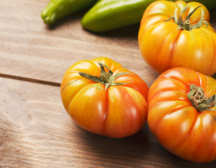 Close-up of Tomatoes and peppers on wooden table. Horizontal shoot. Copyspace.