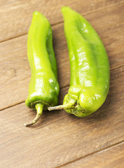 Appetizing green peppers on wooden table. Vertical shoot.