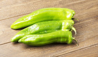 Appetizing green peppers on wooden table. Horizontal shoot.