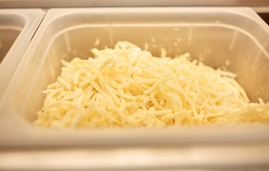 container with grated cheese at restaurant kitchen