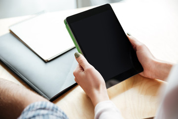 Cropped image of lady in office coworking while using tablet