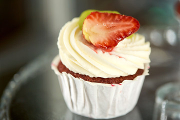 close up of cupcake with cream and strawberry