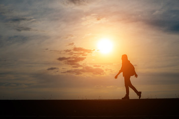 Silhouette of young woman traveler with sunset.