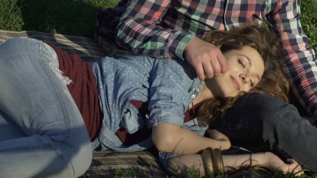 young girl lying in the lap of her boyfriend and resting in nature
