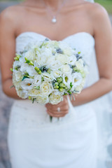 Obraz na płótnie Canvas The bride with a wedding bouquet of white roses