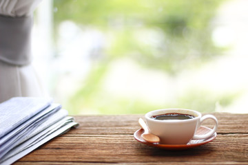 Morning coffee, Cup of coffee with newspapers, near the window.background in the morning sunlight.
