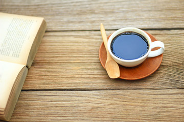 Stock Photo - Open book with cup of coffee on rustic wooden background