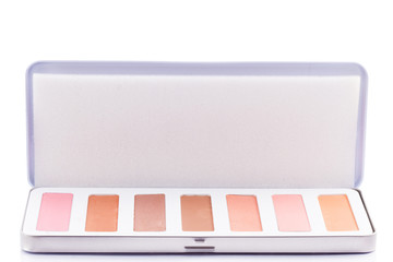 Eyeshadow of different colors over white background in studio photo. Beauty products