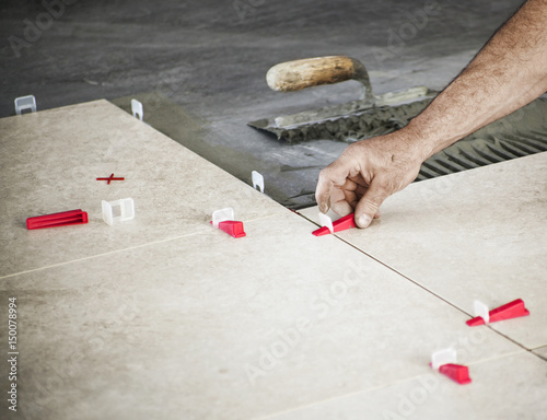 Ceramic Tiles Tiler Placing Tile In Position Over Adhesive Ceramic Tiles Tiler Placing Tile In Position Over Adhesive With Lash Leveling System