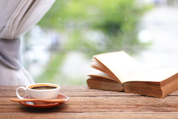 Stock Photo - Cup of coffee with books in morning on the window side