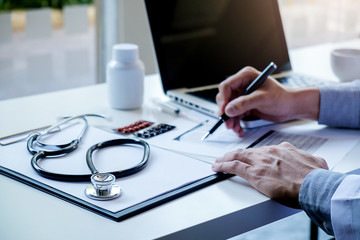 Stethoscope with clipboard and Laptop on desk Doctor working in hospital writing a prescription  Healthcare and medical concept test results in background vintage color selective focus.