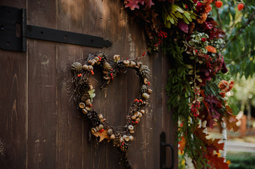 Natural wreath in form of heart on the brown door