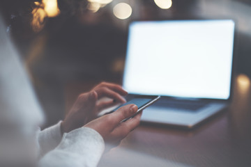 Modern woman using mobile phone, laptop. Digital gadgets close-up. Intentional lens flares and soft focus