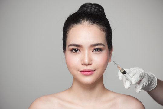 Beautiful asian woman gets beauty facial injections. Face aging injection.