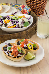 Mini taco boats with black beans and vegetables.