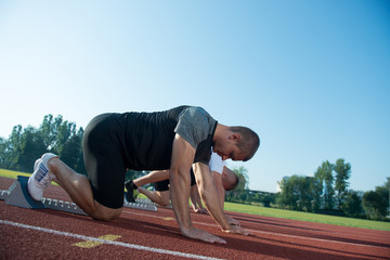 Runners preparing for race at starting blocks