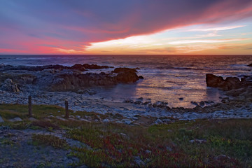 Sunset over rocks and sand at Asilomar State Beach in California