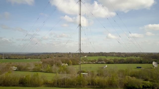 Radio mast antennae and English countryside; drone rising and reveal