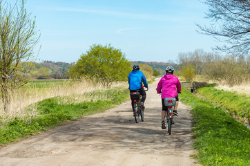 Obraz premium Older people ride a bike in the park