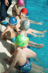 happy children kids group at swimming pool class learning to swim