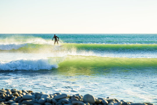 Surfing in ocean. Clear green waves and surfer on wave
