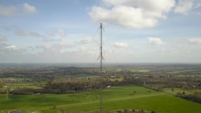 Radio mast antenna and English countryside; drone reverse and reveal