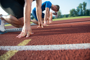 Runners preparing for race at starting blocks