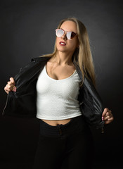 Beautiful woman in black leather jacket and sunglasses .