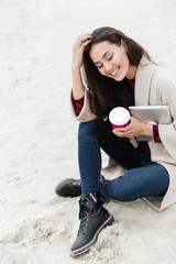 Smiling caucasian woman sitting outdoors at beach