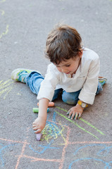 Naklejka premium Child drawing with chalk