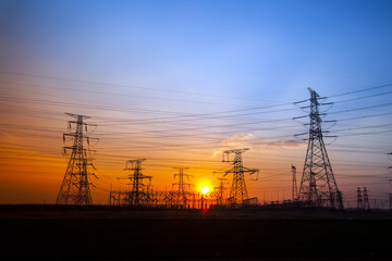 The silhouette of the evening electricity transmission pylon
