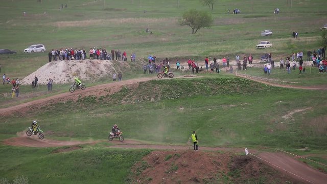 KRAMATORSK, UKRAINE - MAY 08, 2017. Motocross competitions. Overall plan. Several participants make jumps on motorcycles on the mountainside.Rider participates in the round of motocross championship 