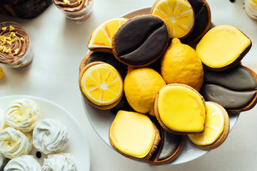 Lemon and coffee biscuits on wedding candy bar. Holiday candy bar in yellow and brown color