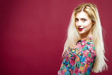 Coquettish Blonde with Sensual Lips Wearing Colorful Shirt on Pink Background. Portrait of Amazing Woman with Long Hair in Studio.