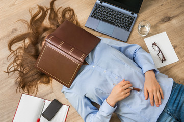 Woman lying on back and covering her face with book