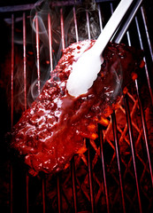 Close up of Smoked Barbecue Pork Spare Ribs on hot flaming grill, selective focus