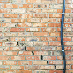 colorful abandoned grunge cracked brick stucco wall and electric cable