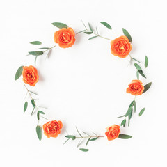 Flowers composition. Wreath made of orange rose flowers and eucalyptus leaves on white background. Flat lay, top view