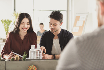 Cheerful colleagues locating in office