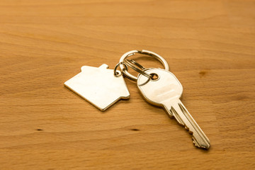 Silver door key placed on wood desk