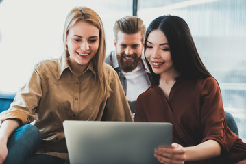 Cheerful colleagues locating in office