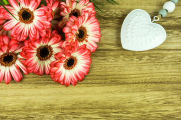 Gerbera flowers with a white heart on a rustic wooden background