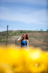 Obraz premium Sexy gorgeous woman in flower field in sunny summer day. Beautiful girl in springtime