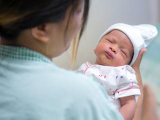 Mother holding her newborn baby child after labor in a hospital.