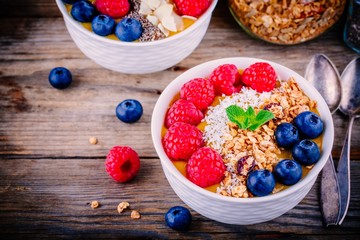 Tropical smoothie bowl with raspberries, blueberries, chia seeds and almonds